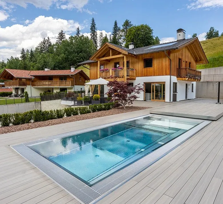Piscina in acciaio inox H2O Style su una terrazza in legno, davanti a uno chalet