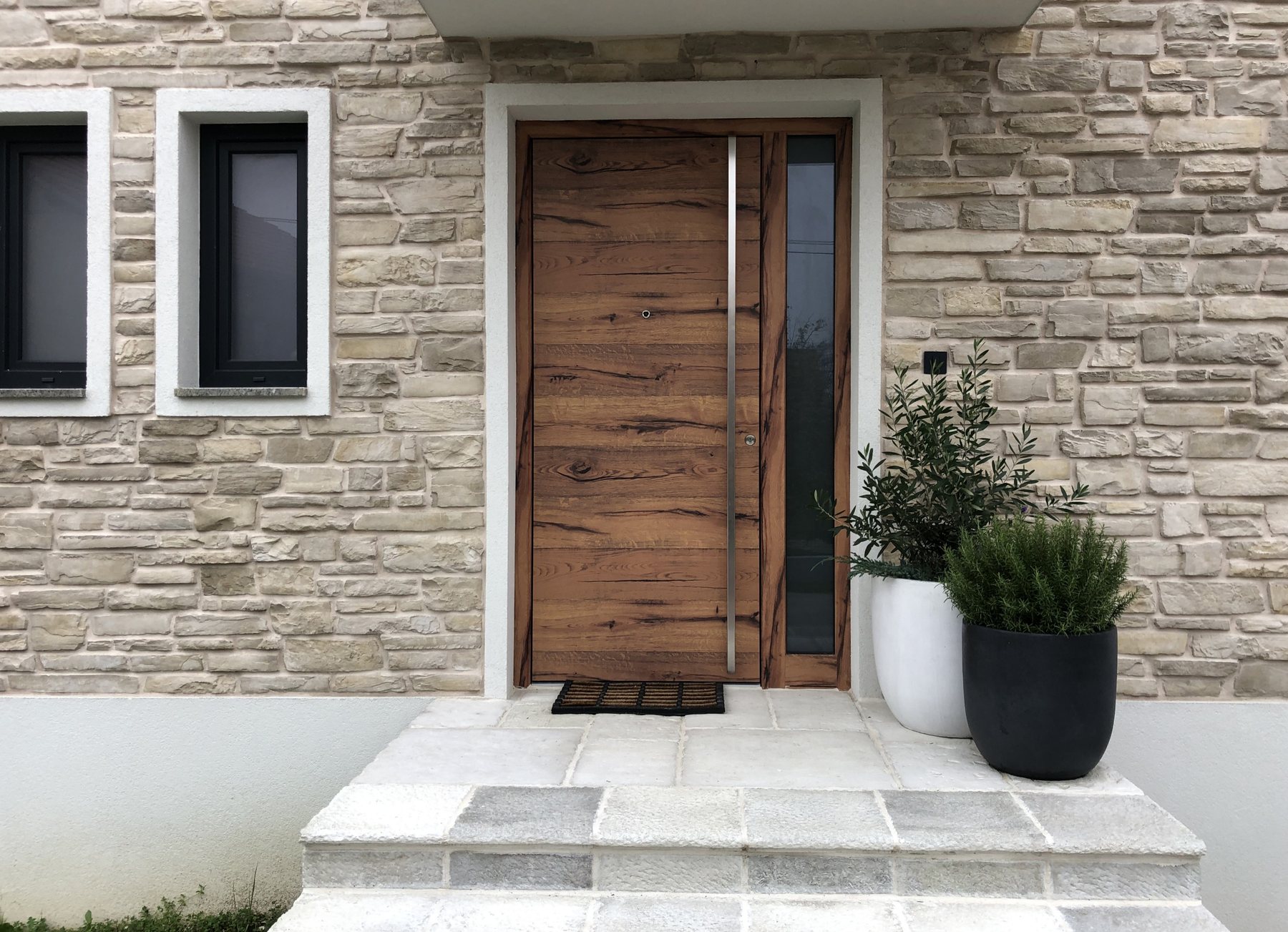 Wooden front door, stone façade · © Inotherm