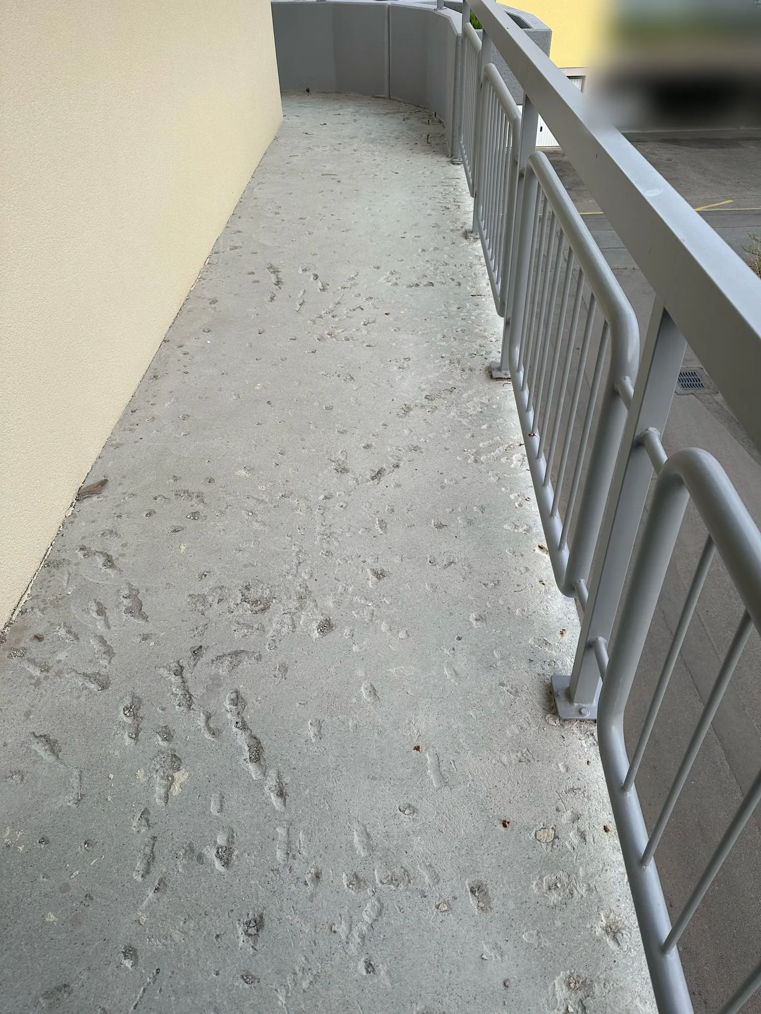 Laubengang mit beschädigtem Betonboden, vor den Arbeiten