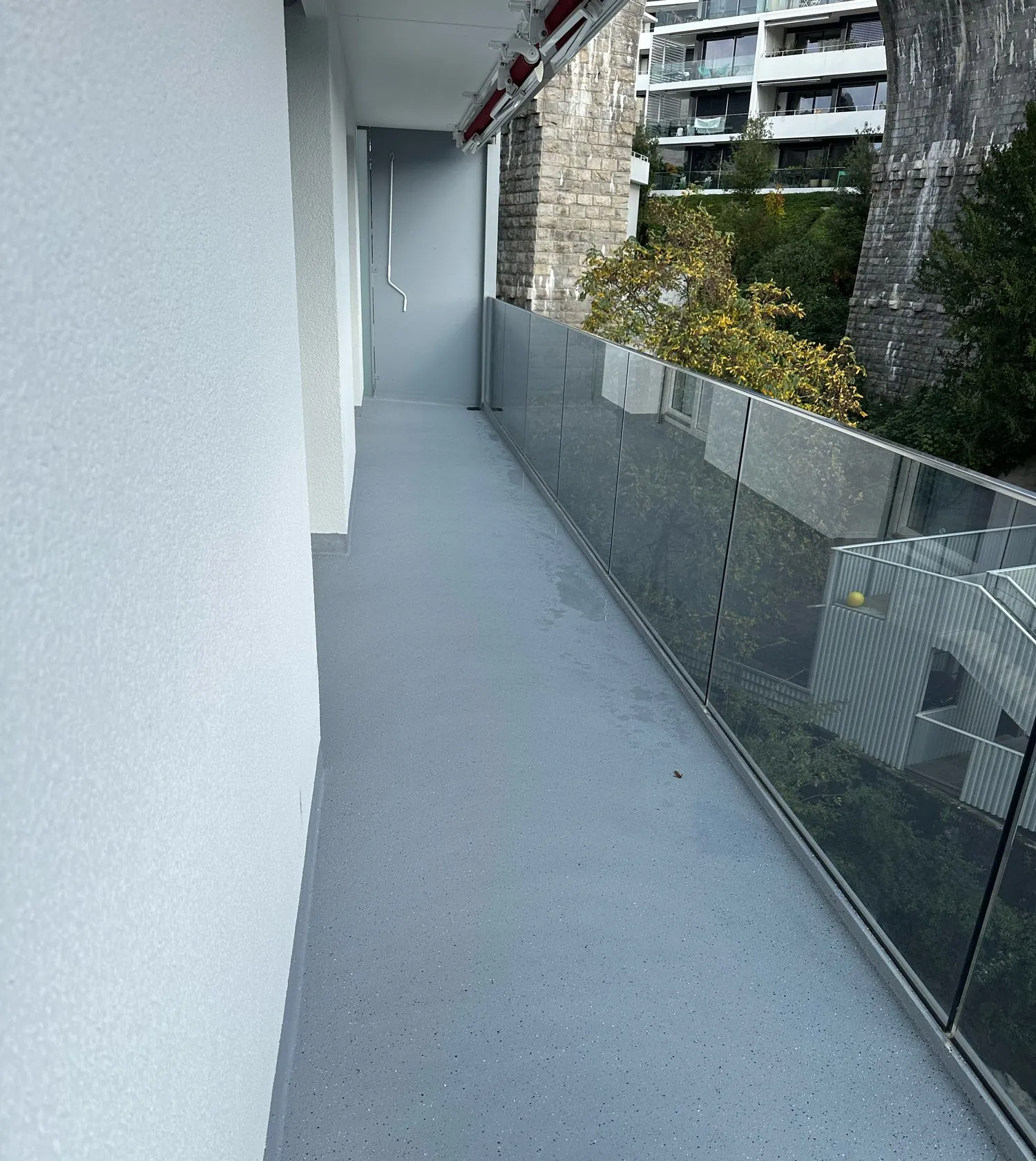 Mit grauem Kunstharz sanierter Laubengang
