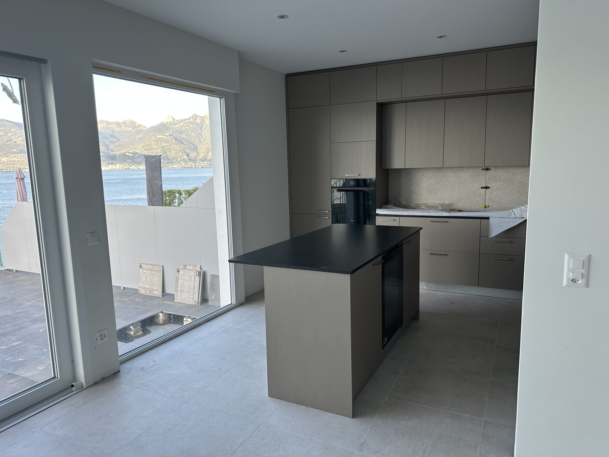 Taupe island with black top in front of the picture windows