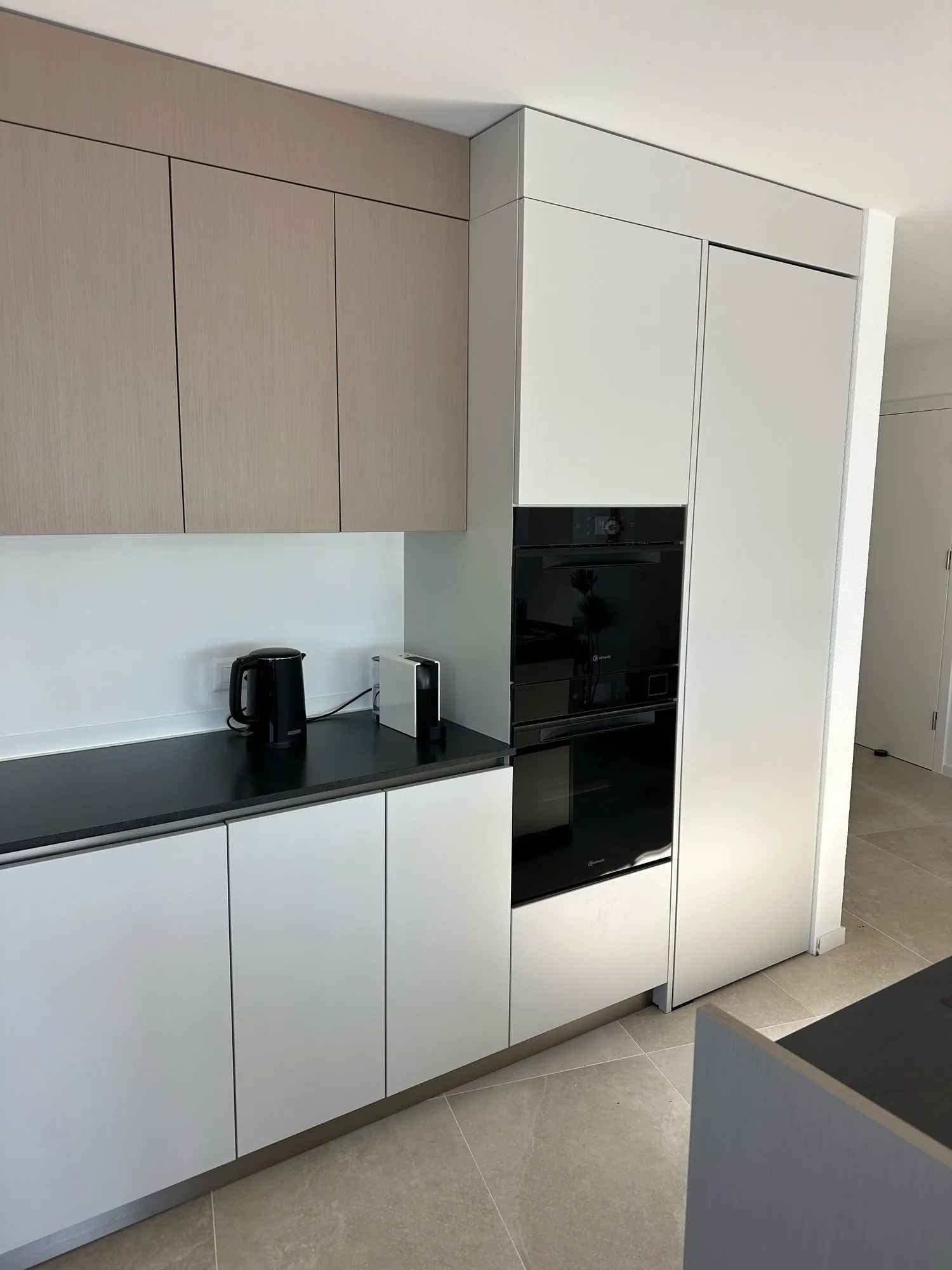 Taupefarbene Oberschränke und weisser Backofen-Hochschrank