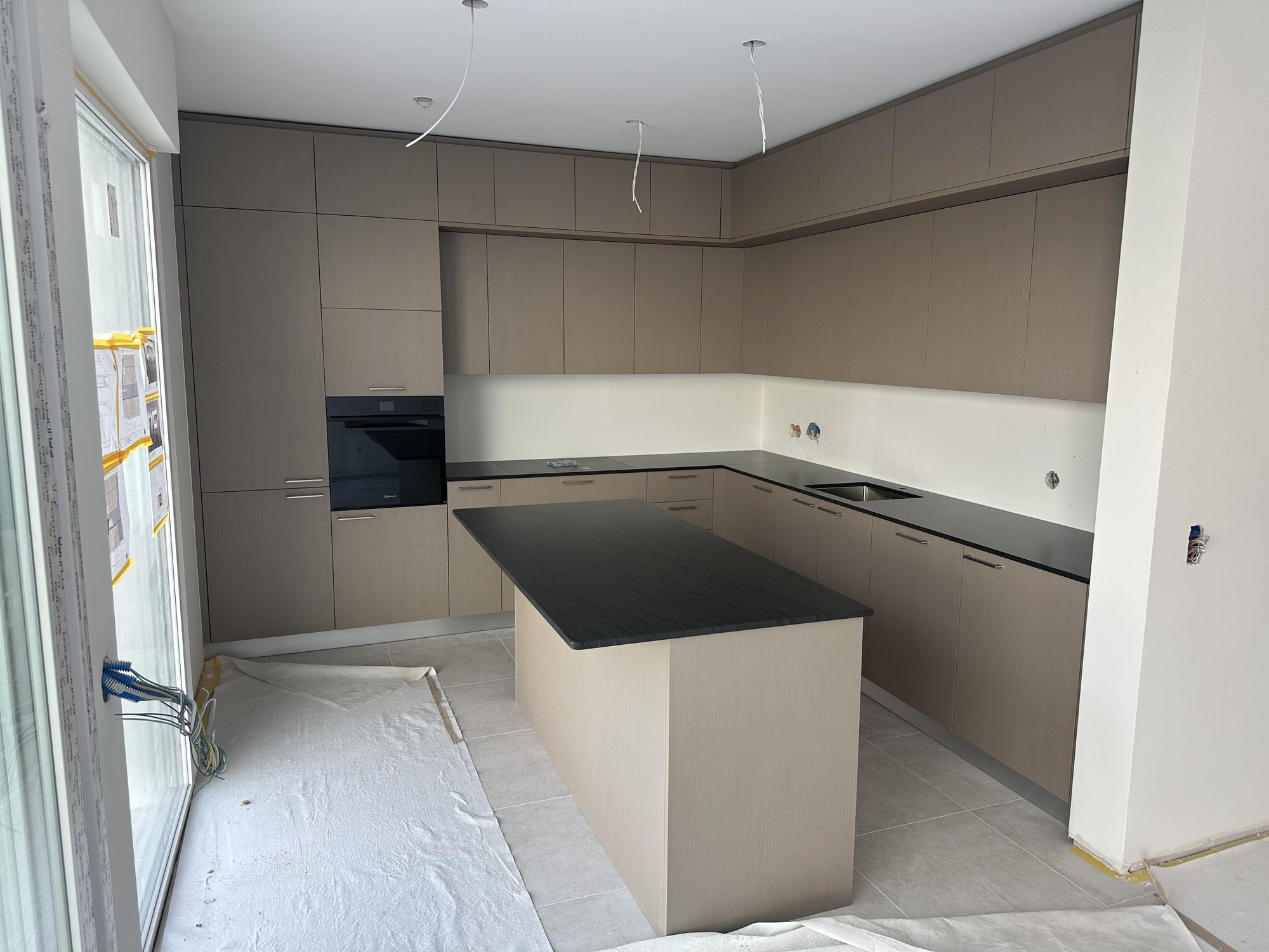 Taupe kitchen at the end of installation, floor still protected