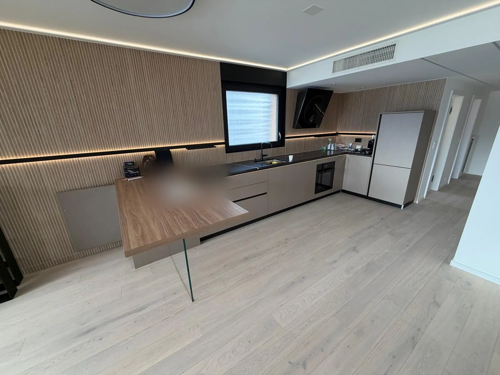 Offene Küche mit beleuchteter Holzlamellenwand