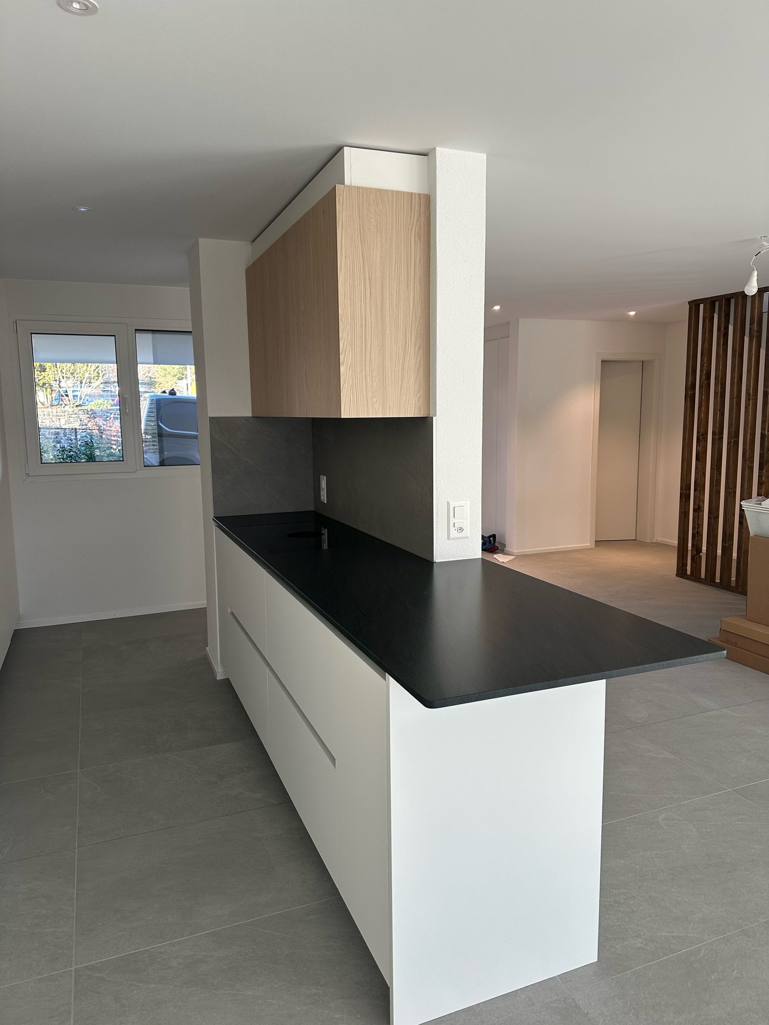 White peninsula with black top, view towards the living room