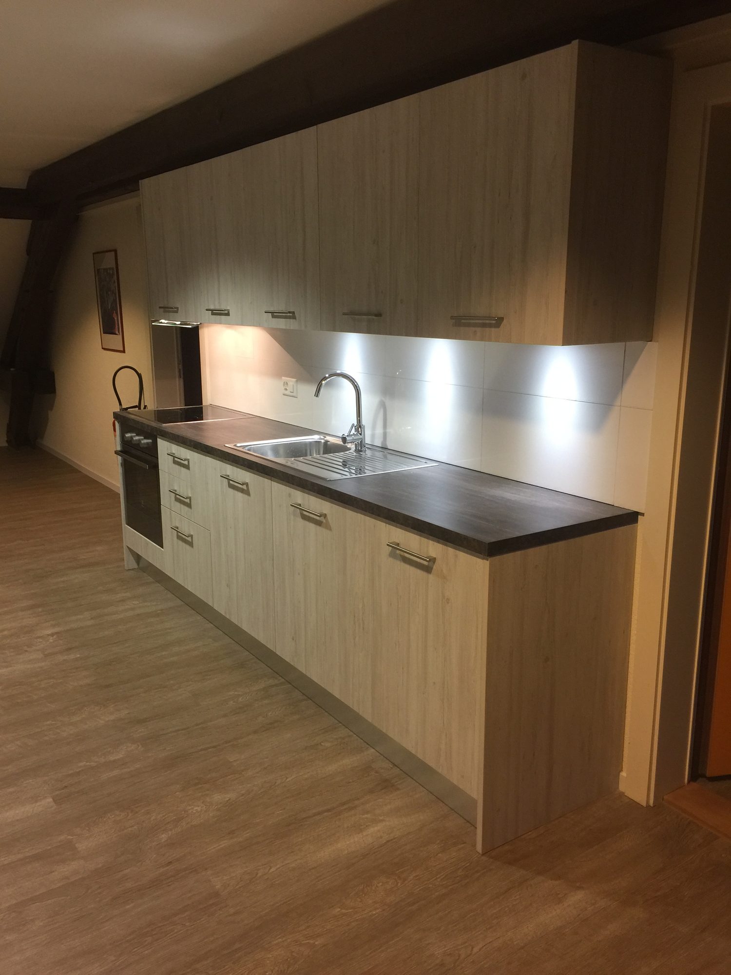 Single-wall kitchen in a light wood finish
