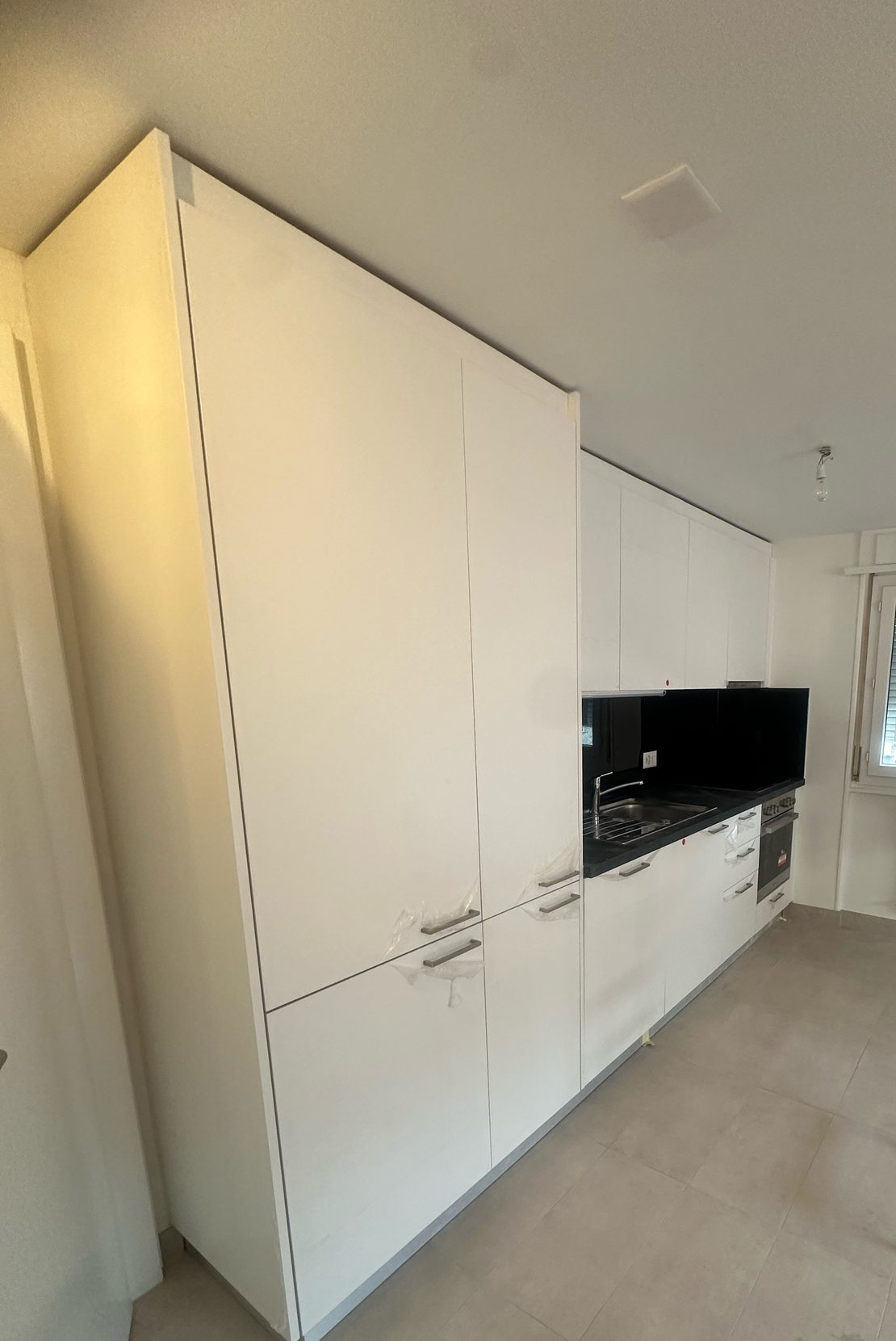 Tall white units and black splashback
