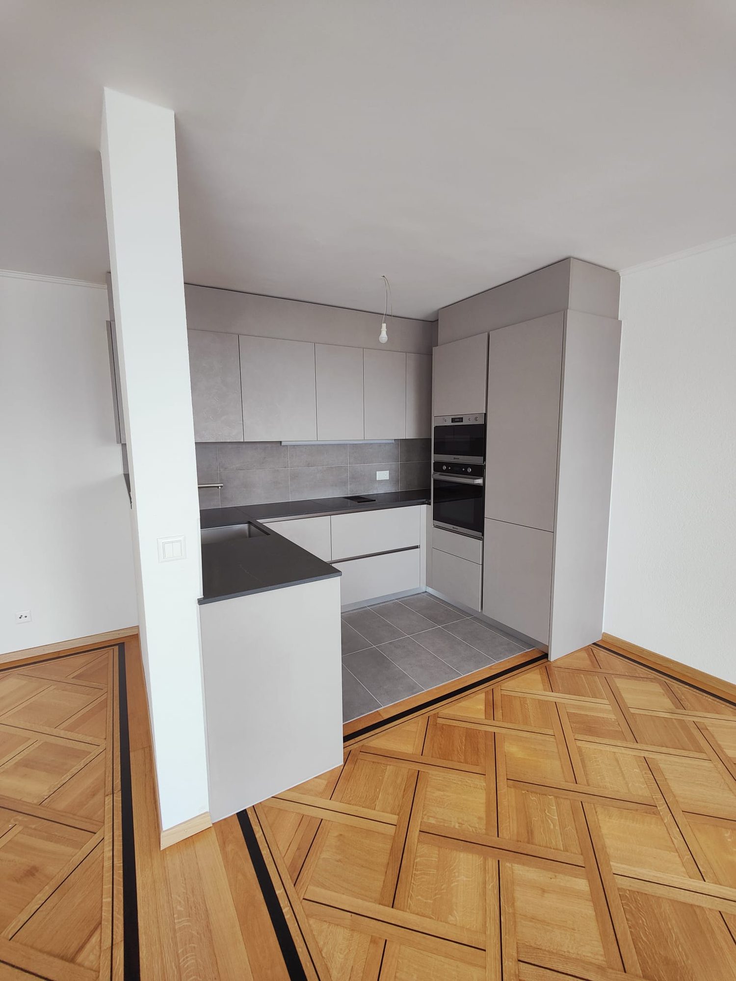 Completed — U-shaped kitchen on parquet flooring
