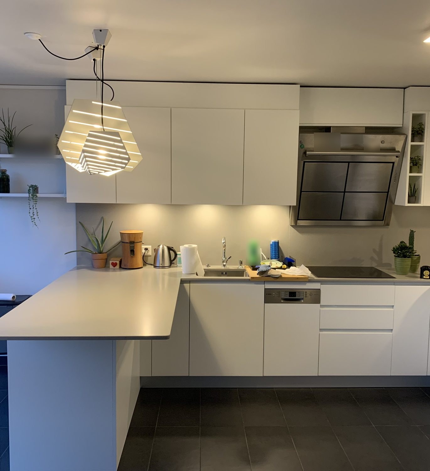 White L-shaped kitchen with stainless-steel hood