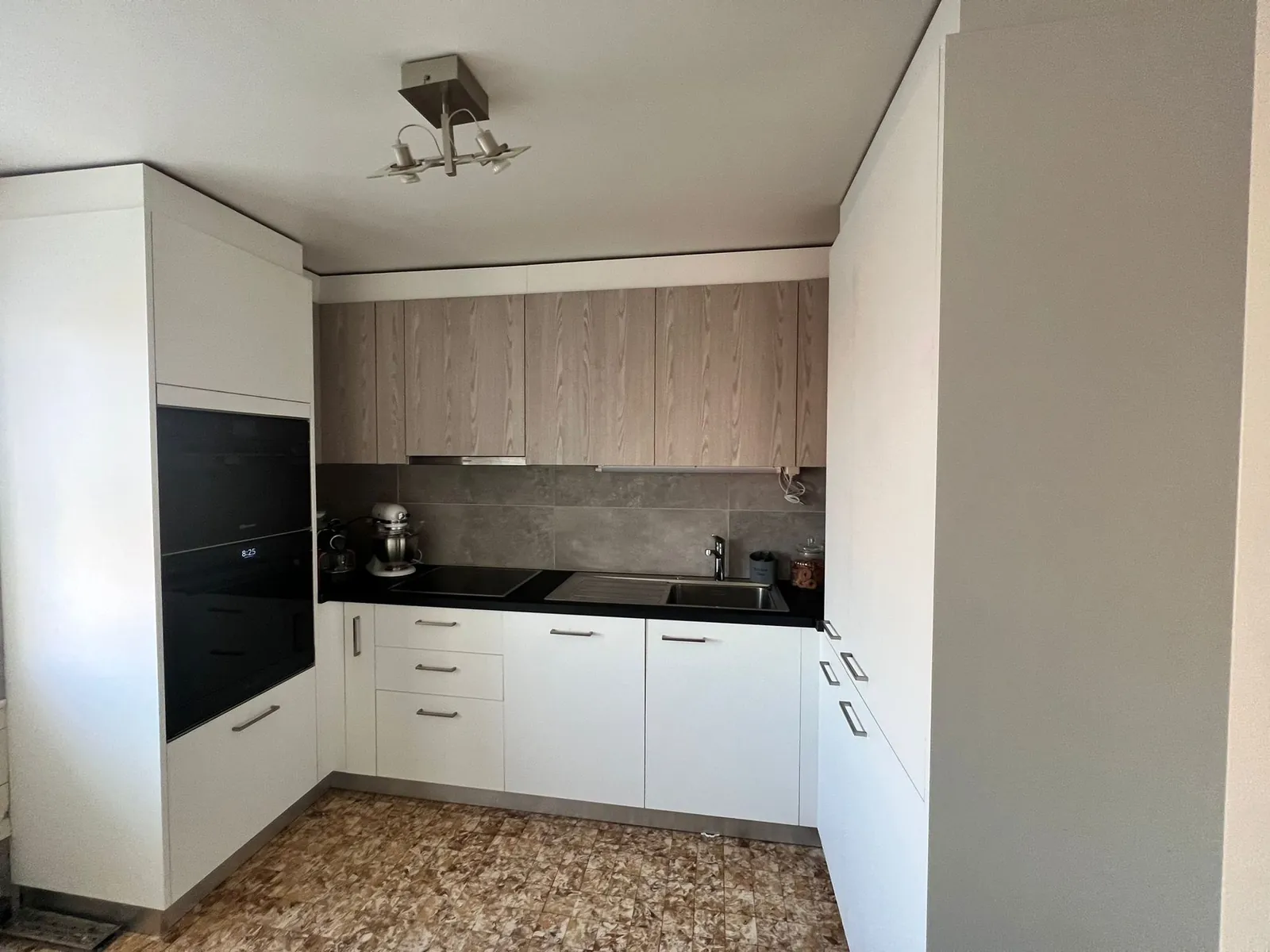 Weisse Küche mit Oberschränken in dunklem Holz