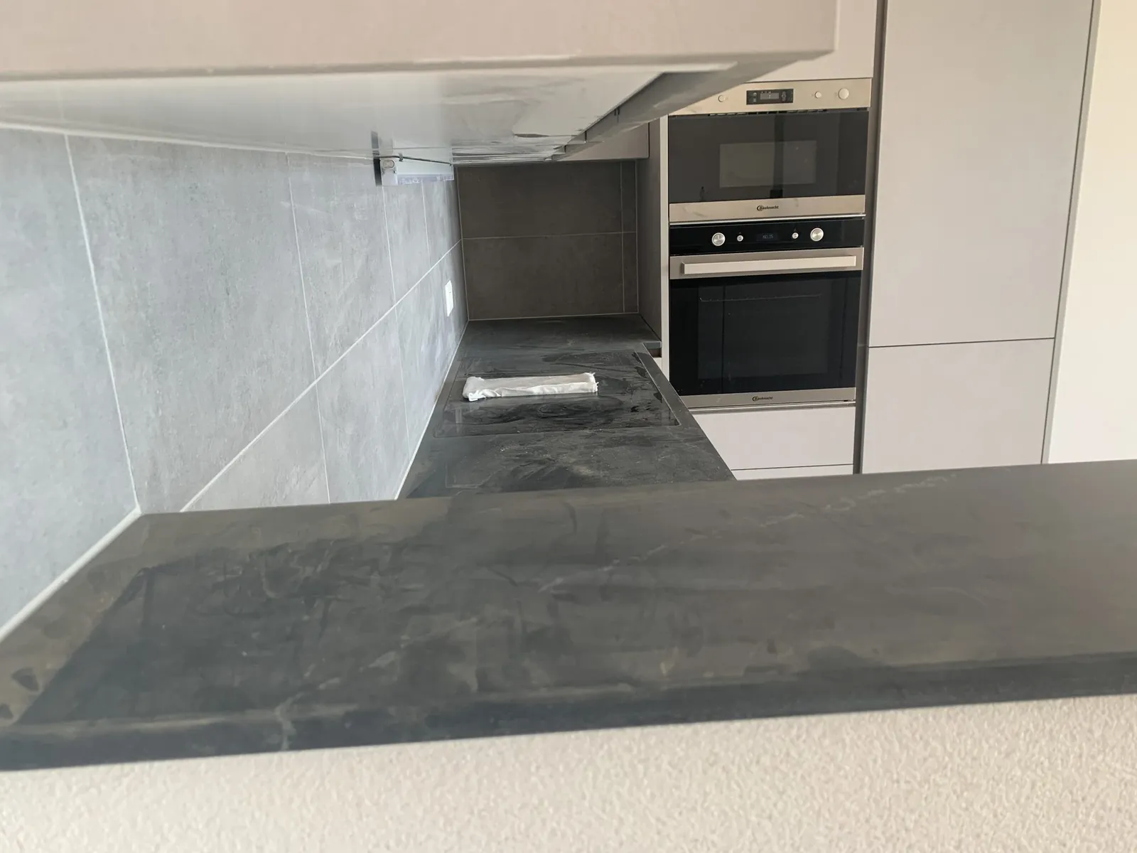 Detail der anthrazitfarbenen Arbeitsplatte und der Backöfen