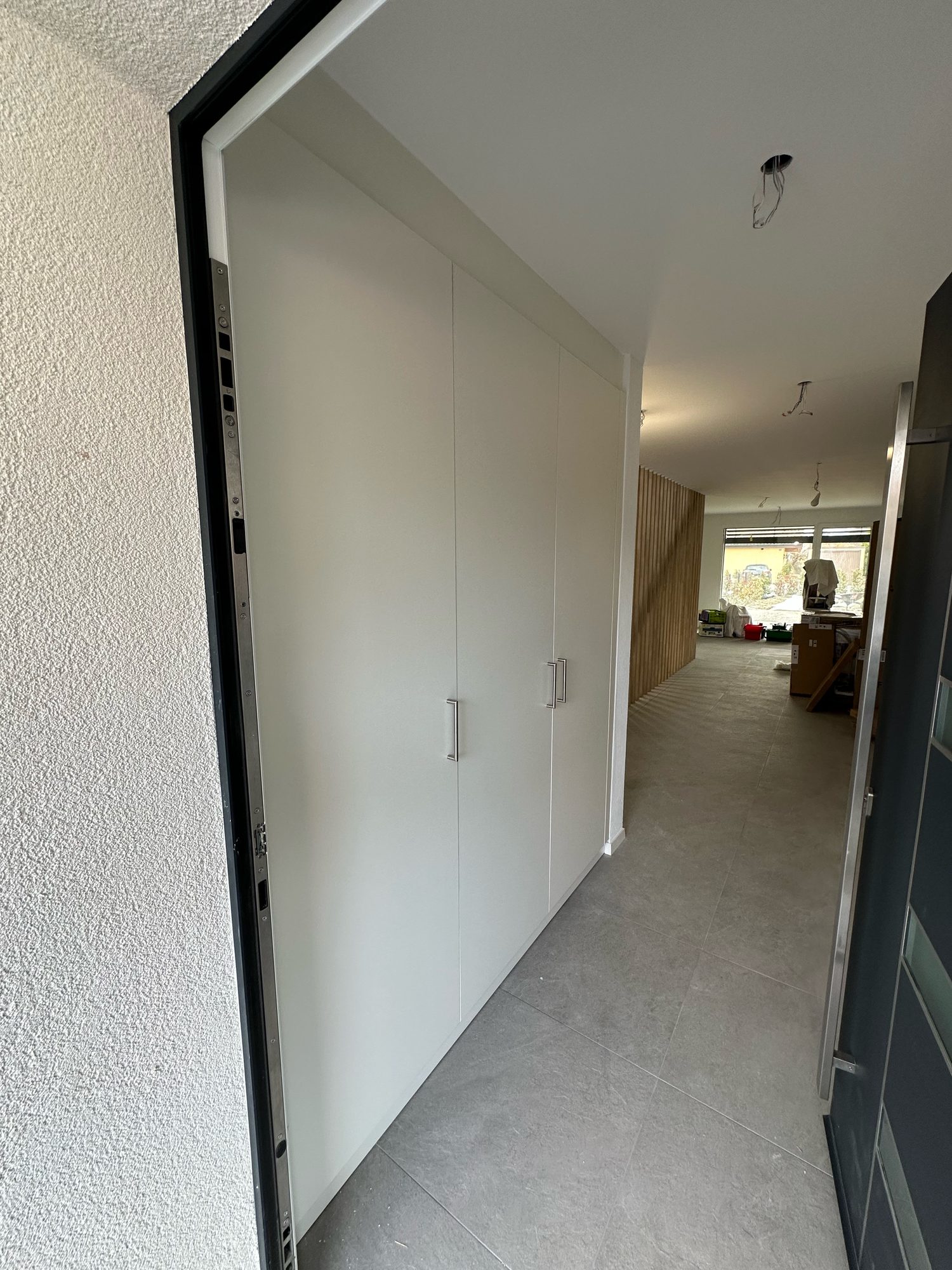 White floor-to-ceiling cupboard in an entrance hall