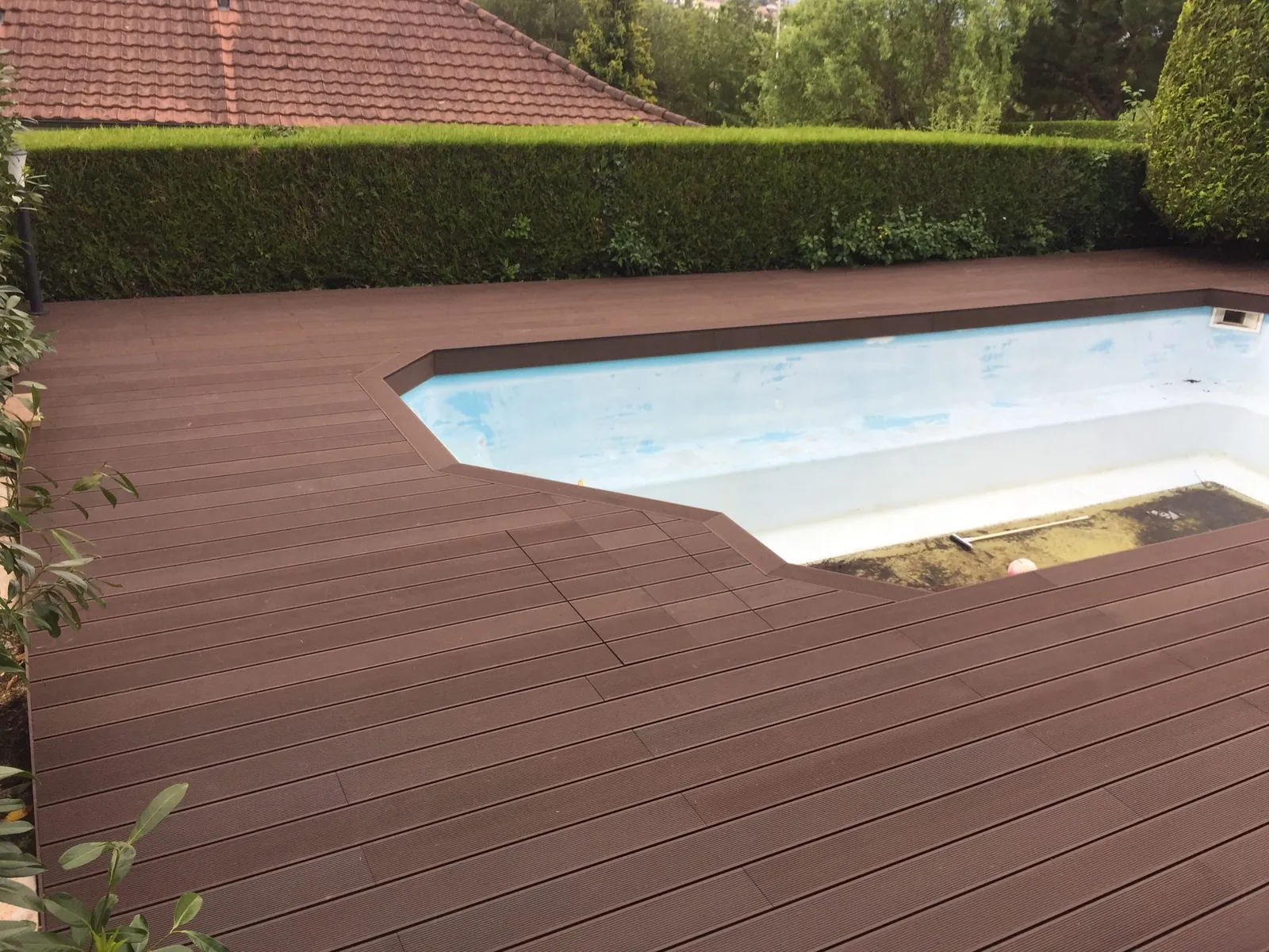 Pool-Umrandung aus braunen Dielen um das Becken