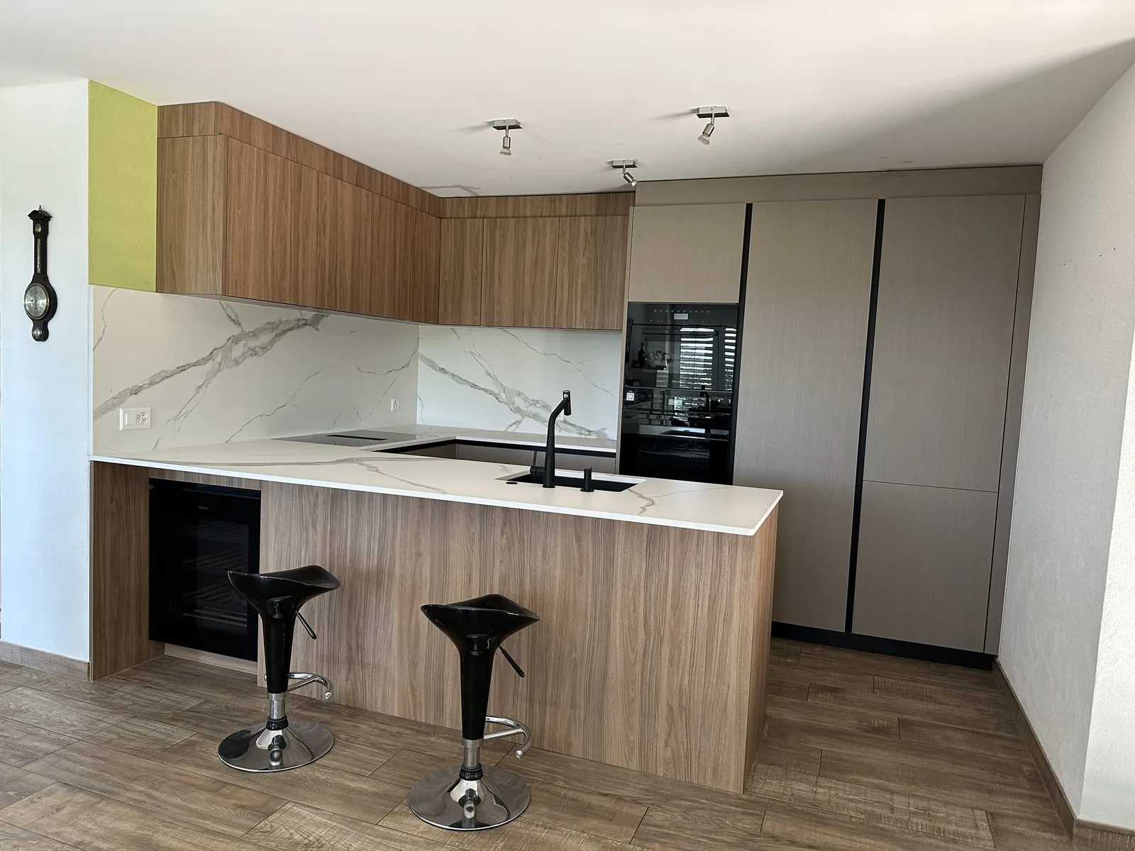 Halbinsel mit Hockern und Holzfronten
