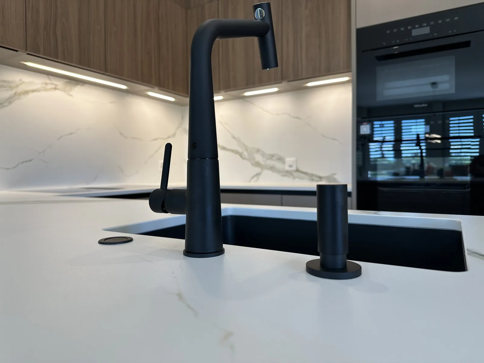 Schwarze Armatur und Rückwand in Marmoroptik