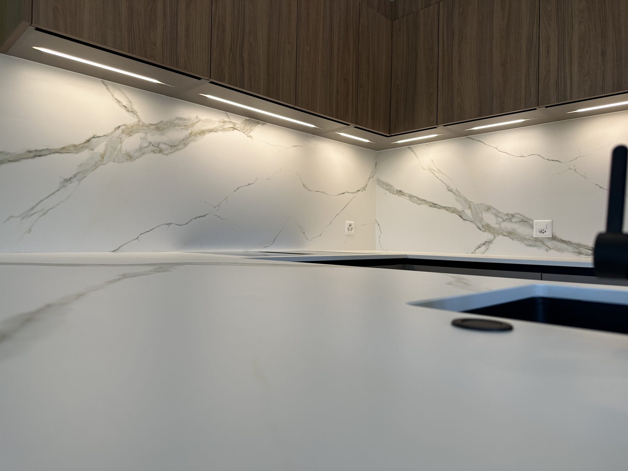 Marble-look splashback and lighting under the wall units