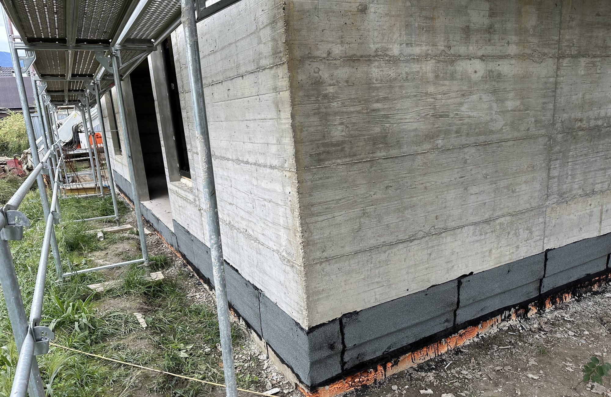 Torch-welded bitumen base along the building
